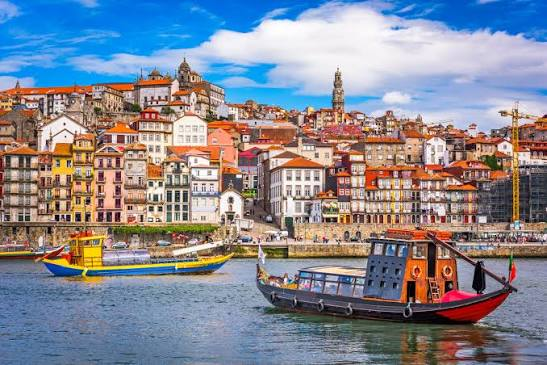The Porto riverfront in daylight, colourful houses above the Douro